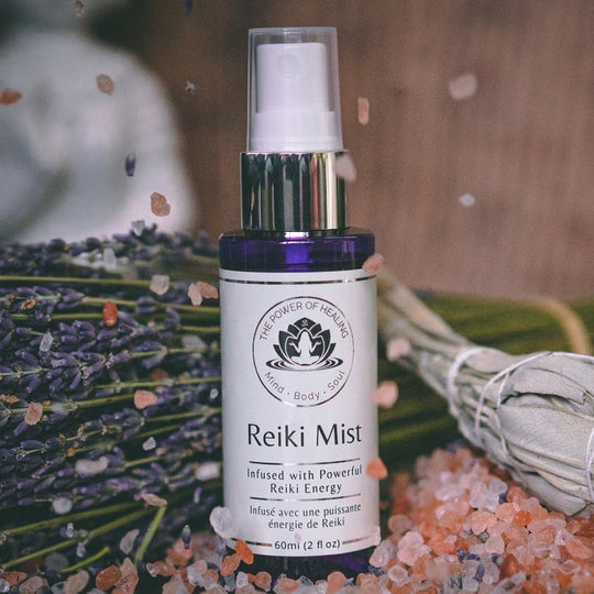 Reiki Mist bottle with lavender and crystals on a wooden surface