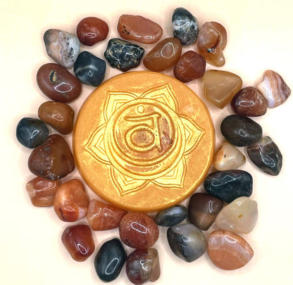 Gold stone with a symbol surrounded by multicolored stones on a white background